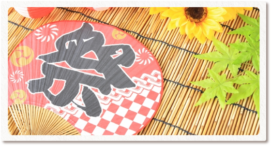 祭りの文字が入ったうちわとひまわり